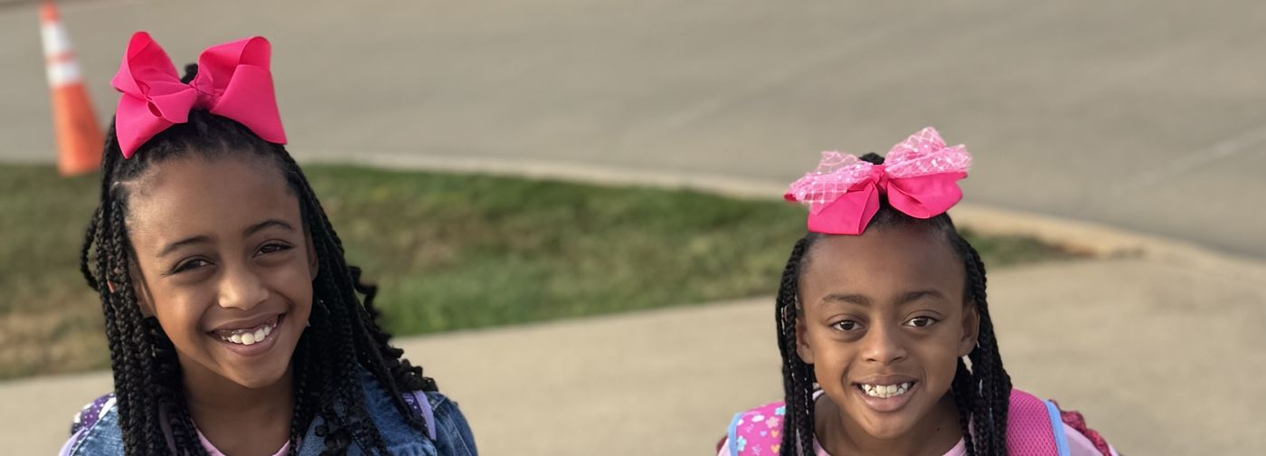Mila G and Mati K smiling in matching pink bows