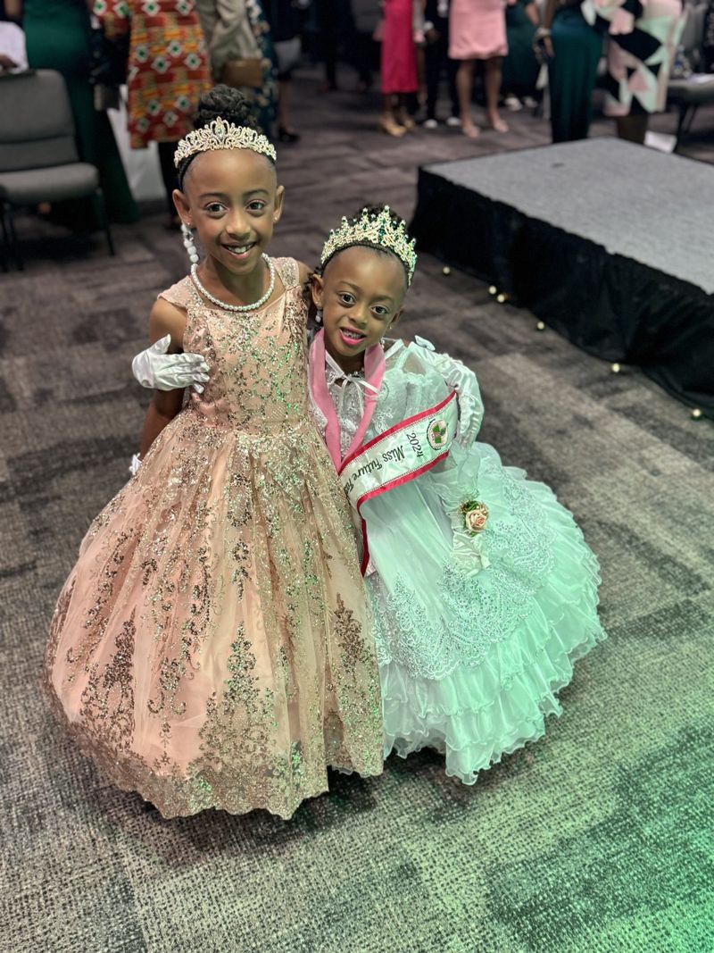 The sisters in gowns and crowns